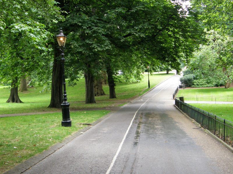 A path in Hyde Park with a lit gaslight