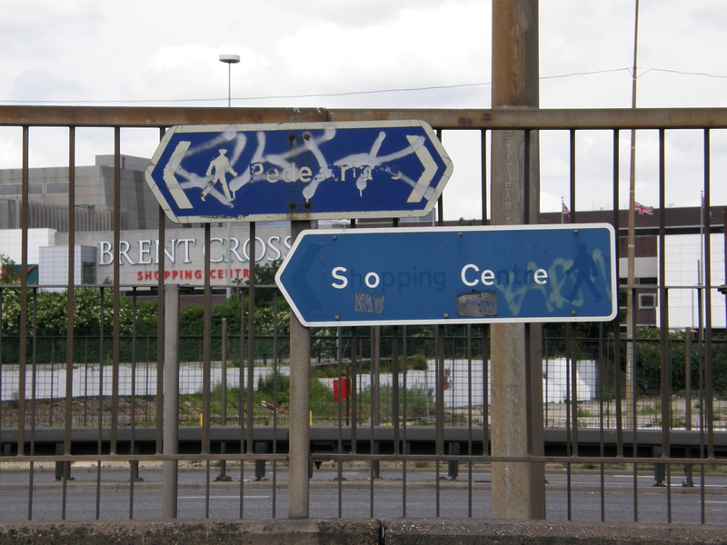 A sign saying 'Shopping Centre' with lots of letters missing